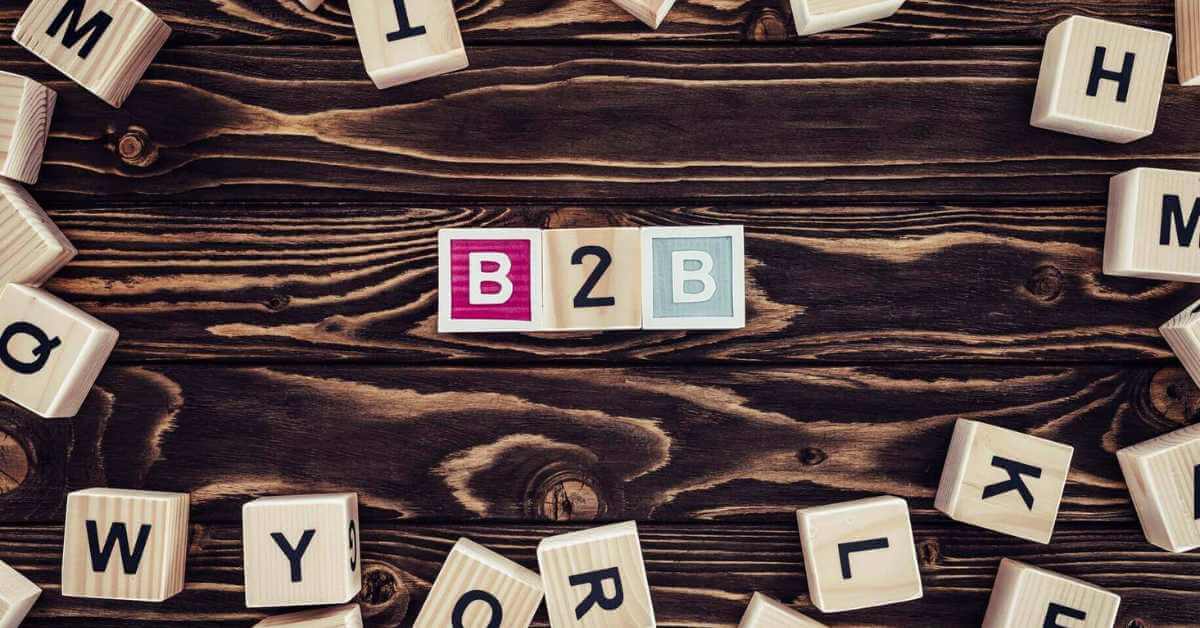 Das Bild zeigt Scrabble Steine auf einem Holztisch, die das Wort B2B bilden
